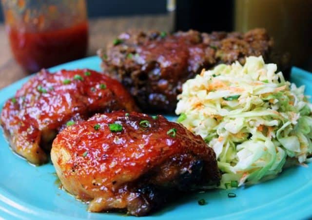 Sticky, tangy, sweet tomato based BBQ sauce is slathered over chicken and caramelized in the oven.