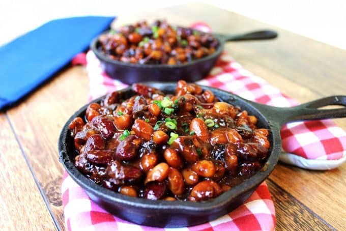 baked beans with bacon served in individual cast iron skillets