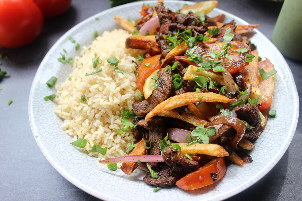 El Pollo Inka's most popular entree, Lomo Saltado, is sliced steak, onions, tomatoes, fries and cilantro topped with spicy green aji sauce and brown rice.