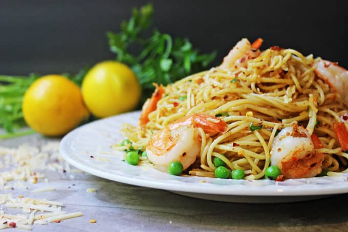 Shrimp Scampi Pasta heaped on plate with peas and parmesan