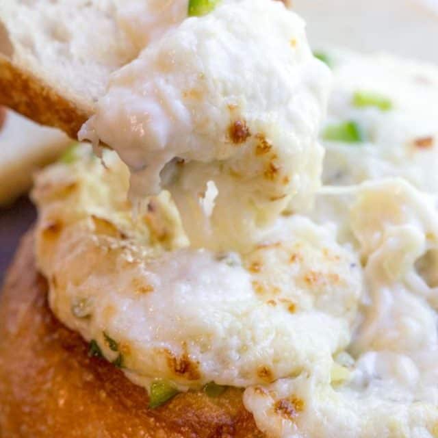 artichoke dip with cream cheese and scallions baked in bread bowl