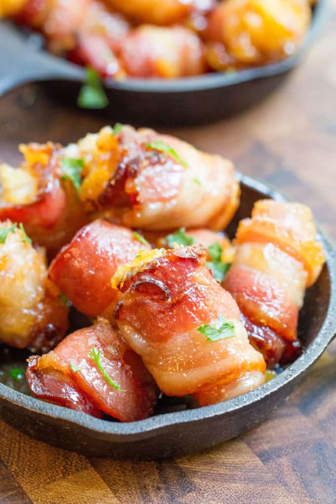 Bacon Wrapped Tater Tot Bombs are an easy appetizer of tater tots and sharp cheddar cheese wrapped in thick cut bacon, rolled in brown sugar and baked.