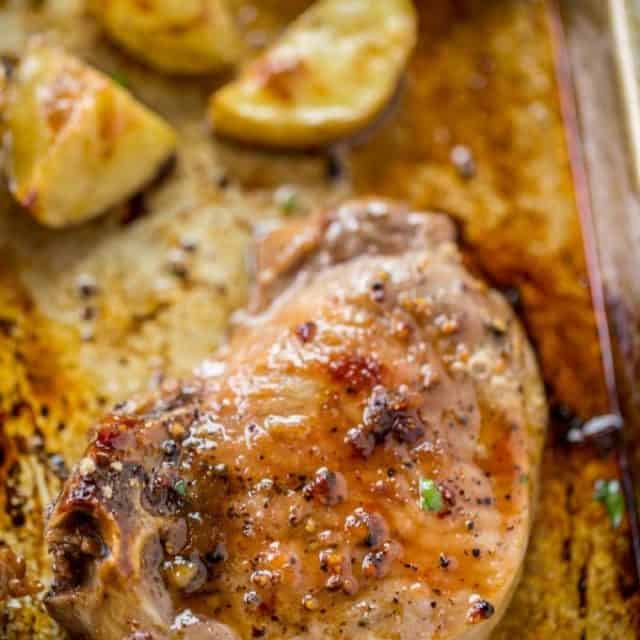 Oven Baked Pork Chops covered in brown sugar and garlic made on a sheet pan with yukon potatoes. One pan, almost no cleanup and the whole family will love them.