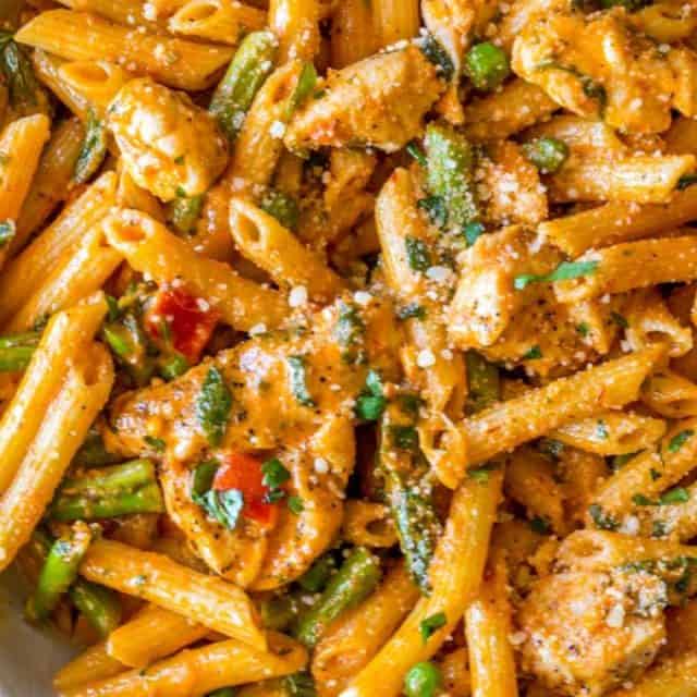 Spicy Chicken Chipotle Pasta from The Cheesecake Factory with asparagus, bell peppers and peas with honey glazed chicken in a spicy chipotle parmesan cream sauce.