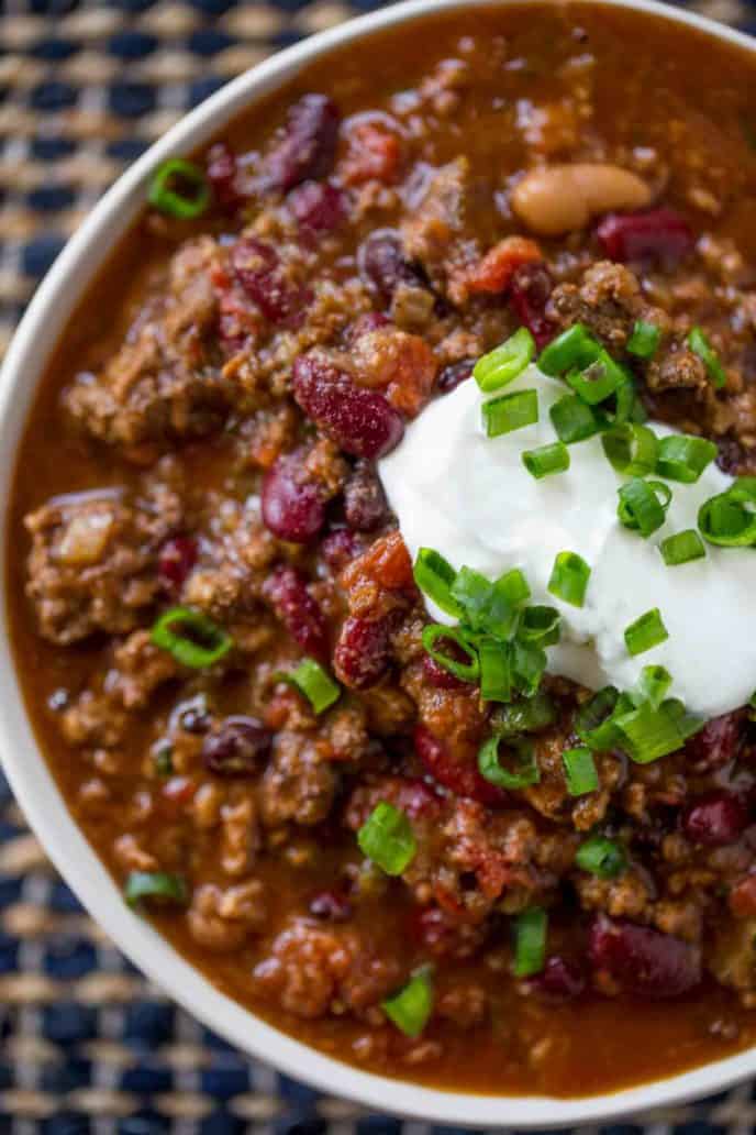 crockpot chili topped with sour cream and onion