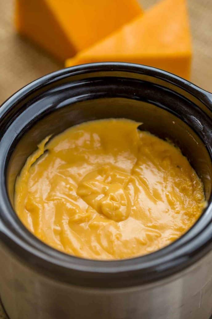 Slow Cooker Nacho Cheese Sauce made with no processed cheese and just four ingredients total! Perfect for game day snacks!