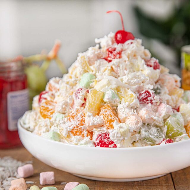 Ambrosia Salad in White bowl with fruit and marshmallows on table