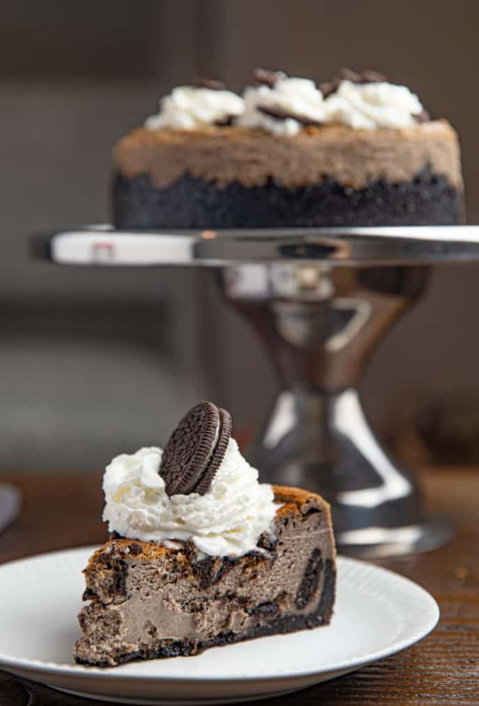 Slice of Oreo Cheesecake with Oreo Cheesecake in Background