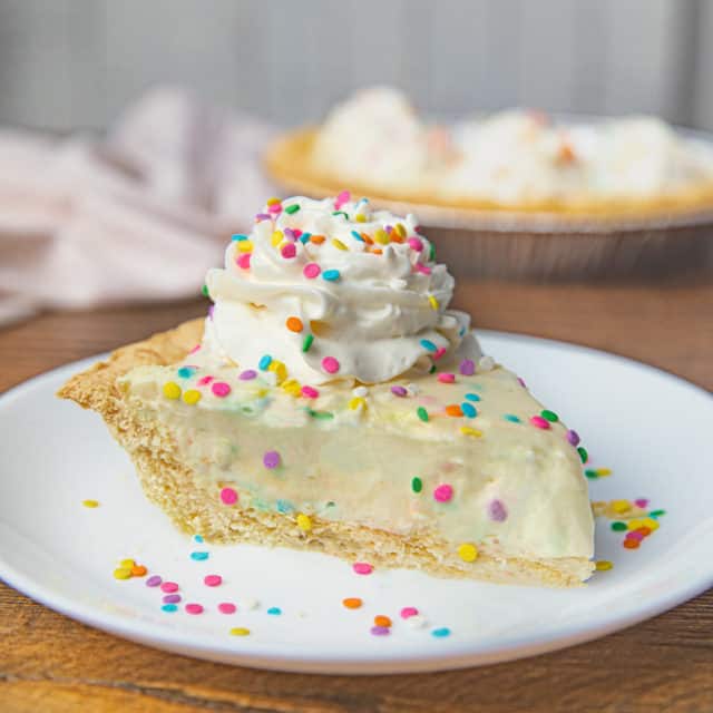 Slice of Birthday Cake Pie with Whipped Cream and Rainbow Sprinkles