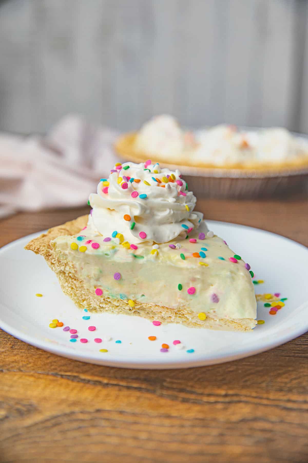Slice of Birthday Cake Pie with Whipped Cream and Rainbow Sprinkles