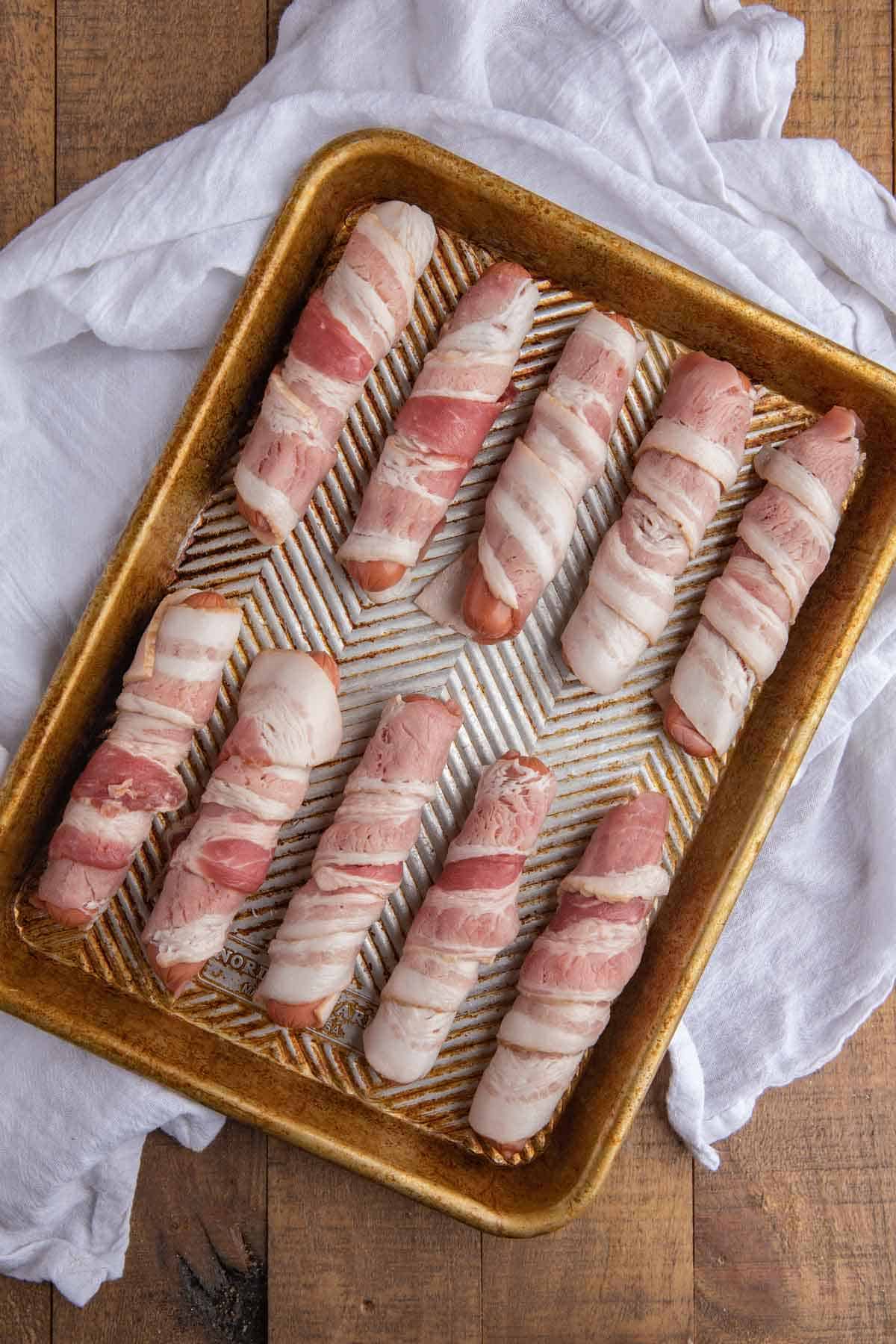 Raw Bacon wrapped around hot dogs