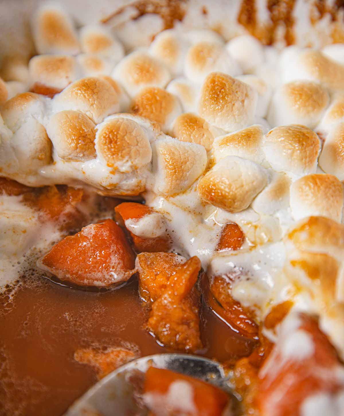 Candied Sweet Potatoes with Marshmallows scooped out of baking dish