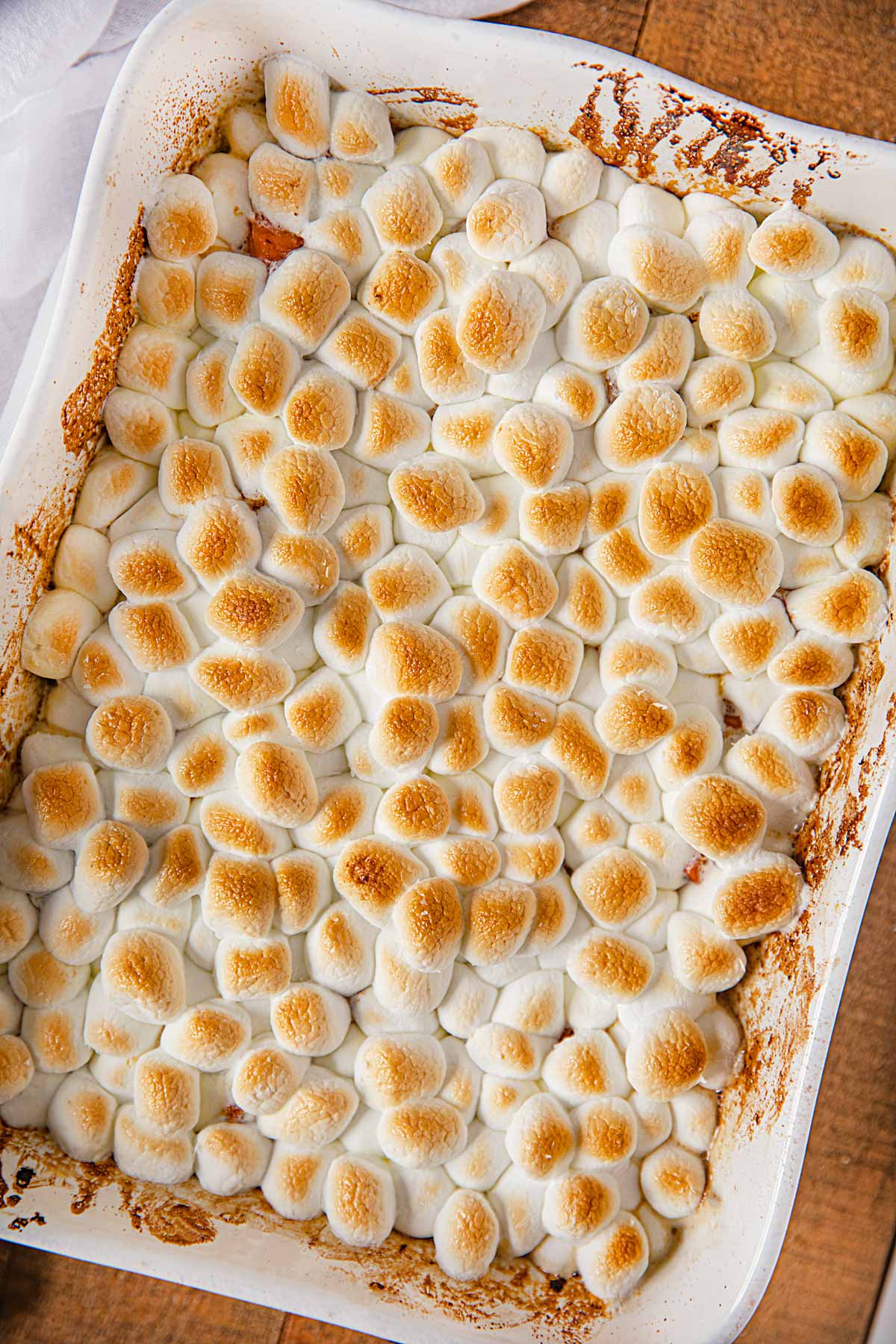 Candied Sweet Potatoes in baking dish topped with toasted marshmallows