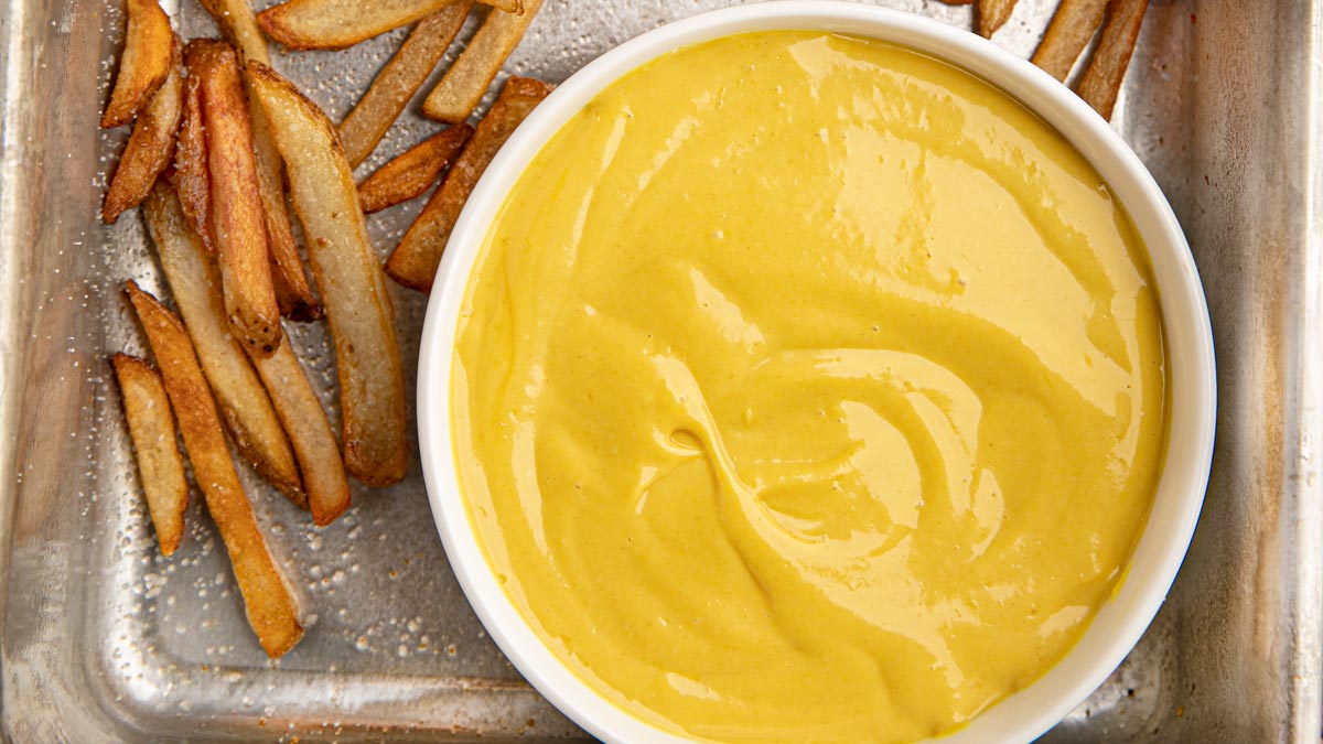 Honey Mustard in white bowl in tray with baked french fries